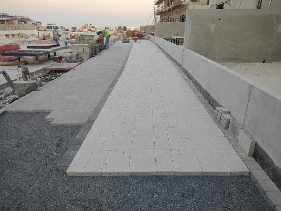 Completed public-realm paving and kerb edging, handed over to line and level — Al Reem Island.